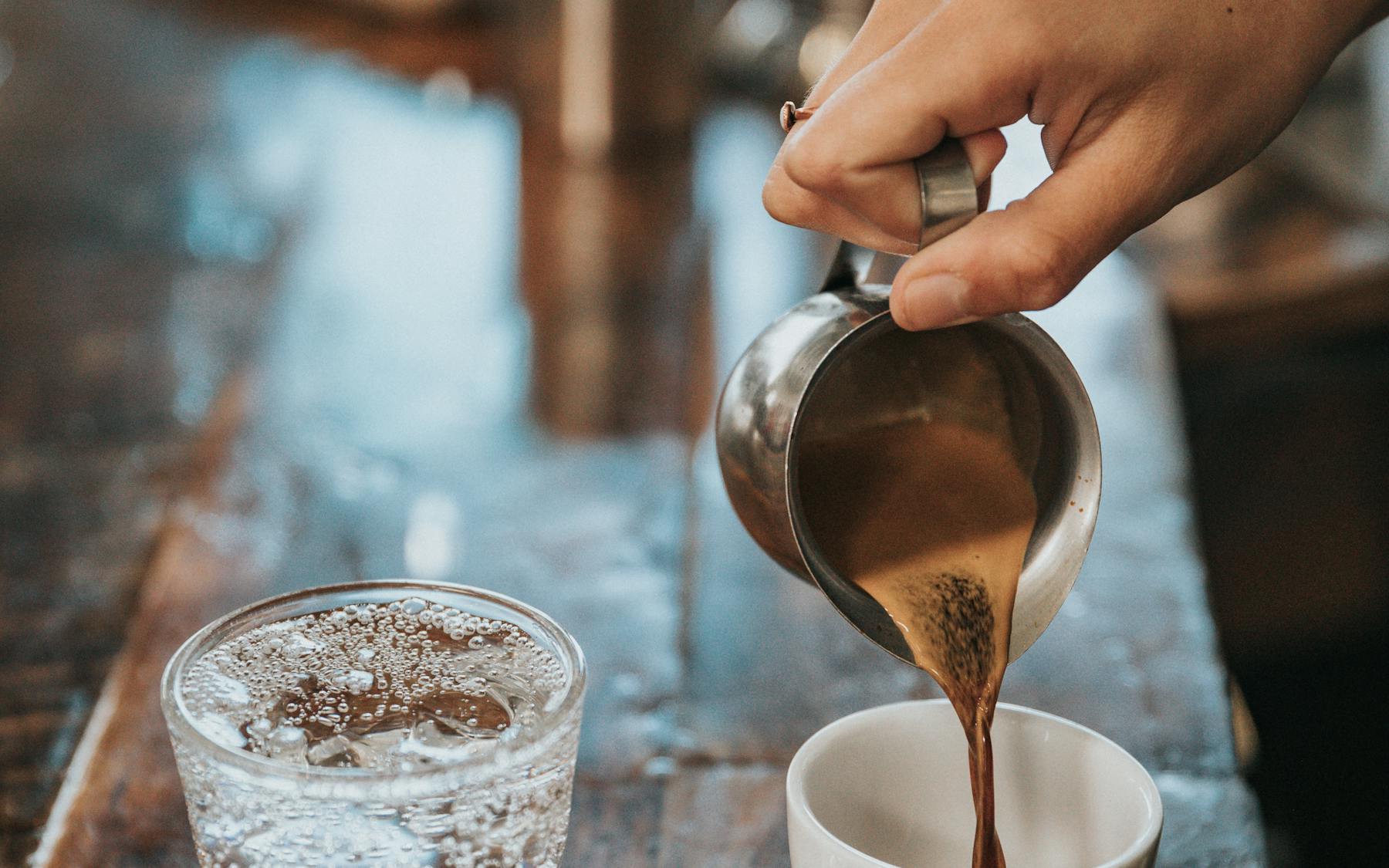 Professionelle Zweigruppen-Siebträgermaschine im laufenden Cafébetrieb, Tassen auf der Tassenablage